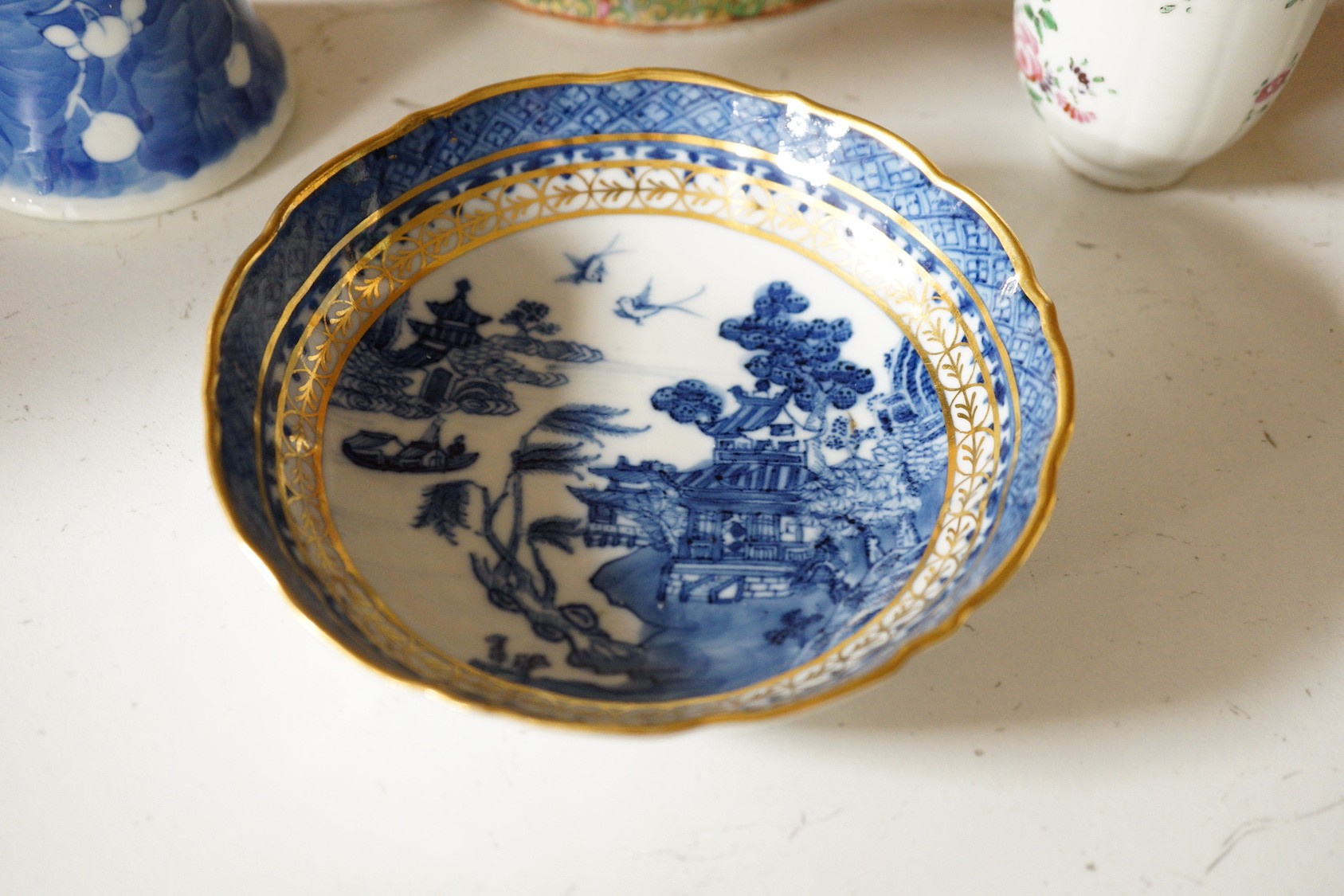 A Chinese famille rose teapot and cover, a blue and white prunus vase, a saucer and a coffee cup, 18th/19th century, tallest 19cm